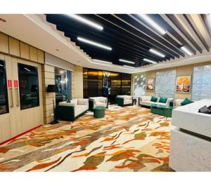 a lobby with couches and chairs on a large rug at Evara Exotica in Darbhanga