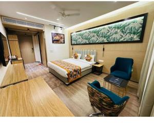 a hotel room with a bed and a table and chairs at Evara Exotica in Darbhanga