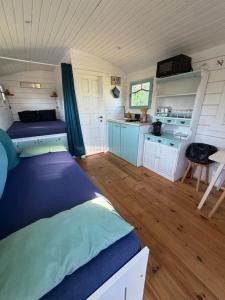 a small room with a bed and a kitchen at La Roulotte à Raven in Le Houga