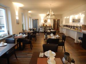ein Restaurant mit Tischen und Stühlen und einer Bar in der Unterkunft Hotel Neptuns Ankerplatz & Zur Seerobbe in Cuxhaven