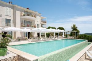 a villa with a swimming pool and white umbrellas at VILLA STEFANIJA small Boutique hotel&restaurant in Barban