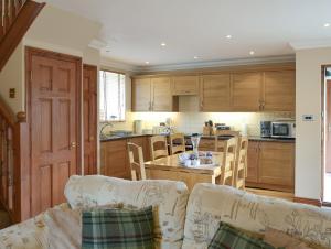 a kitchen with wooden cabinets and a table with chairs at Waren View in Warenford
