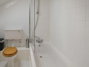 a white bathroom with a toilet and a shower at Waren View in Warenford +5 photos