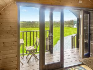 a screened in porch with a chair on a deck at Pencaerau Pods - Enlli Pod in Pwllheli