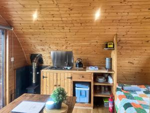 a kitchen in a log cabin with a table at Pencaerau Pods - Enlli Pod in Pwllheli