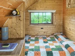 a bedroom with a bed in a wooden cabin at Pencaerau Pods - Enlli Pod in Pwllheli