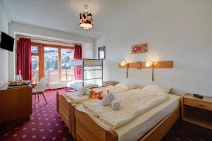 a bedroom with a large bed and a desk at Hotel Relais Alpin in Les Mosses