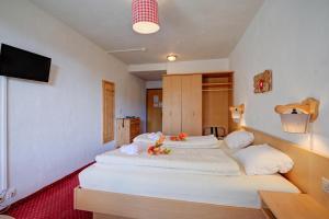 a hotel room with two beds with a tv at Hotel Relais Alpin in Les Mosses