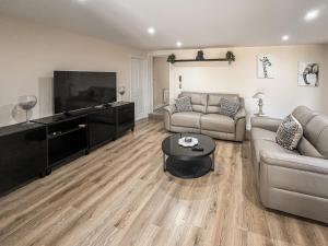 a living room with a couch and a flat screen tv at Jubilee Farm Cottage in Washingborough