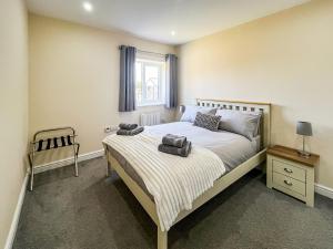 a bedroom with a bed with two towels on it at Jubilee Farm Cottage in Washingborough