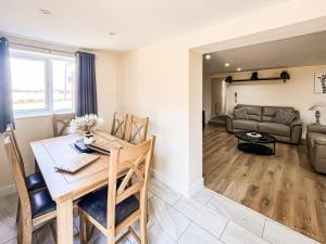 a kitchen and living room with a table and a couch at Jubilee Farm Cottage in Washingborough