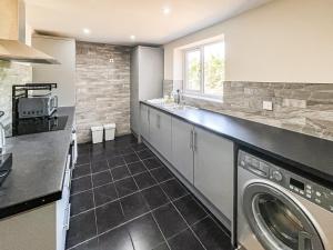 a kitchen with a washer and dryer in it at Jubilee Farm Cottage in Washingborough