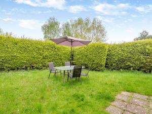 a table and chairs with an umbrella in the grass at Swallow - Uk41035 in Marston