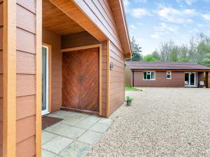 a house with a large wooden door next to a driveway at Swallow - Uk41035 in Marston