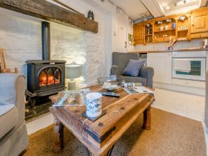 a living room with a table and a wood stove at Fishermans Cottage in St Ives