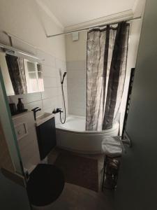 a small bathroom with a tub and a shower at Portside studio, free parking, self check-in in Klaipėda +19 photos
