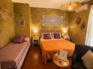 a small bedroom with two beds and a couch at La Mammola Bed&Breakfast in Fabriano