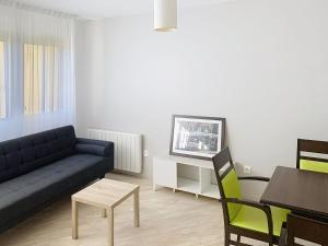 a living room with a couch and a table at Terres de France - Appart Hôtel Rouen Flaubert in Rouen