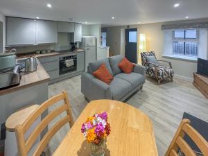 a kitchen and living room with a table and a couch at Wagglehead Cottage in Aboyne