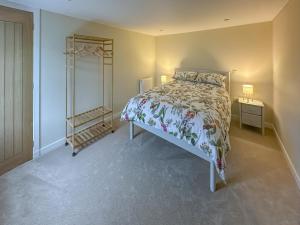 a bedroom with a bed and a dresser and a mirror at Wagglehead Cottage in Aboyne
