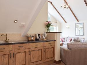 a kitchen with a sink and a living room at Brynymor Cottage in Llangennith