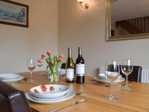 a table with two bottles of wine and glasses at Brynymor Cottage in Llangennith