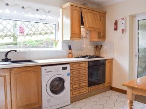 a kitchen with a washing machine and a window at Brynymor Cottage in Llangennith +9 photos