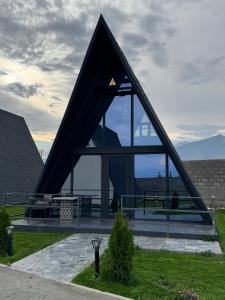 a building with a triangular roof with a large window at SHAM A-frame in Bayetovka