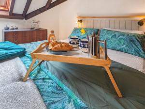 a table with bread and croissants on a bed at Saddlers Cottage in Melrose +15 photos