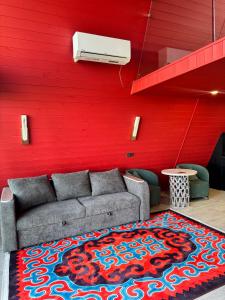 a living room with a couch and a red wall at SHAM A-frame in Bayetovka