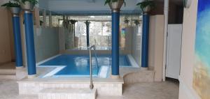 a swimming pool with blue columns and a shower at Aktiv Hotel Schweiger in Füssen