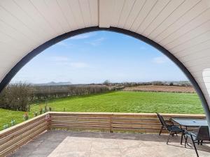 an arched window on a patio with a table and chairs at Squirrels Retreat - Uk46127 in Nesscliffe