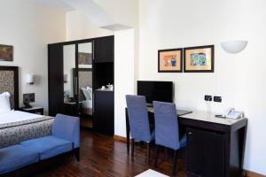 a bedroom with a bed and a desk with blue chairs at Residenza Mecenate in Rome