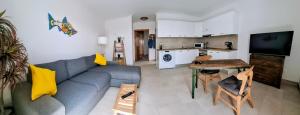 a living room with a couch and a table and a kitchen at Apartamento Aliciamin in Costa Calma