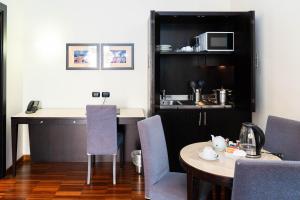 a room with a table and chairs and a kitchen at Residenza Mecenate in Rome