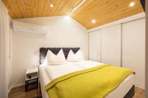 a bedroom with a large bed with a yellow blanket at Chalet Stuhleckblick Ferienhaus mit Sauna, Panorama und Terrasse in Spital am Semmering +35 photos