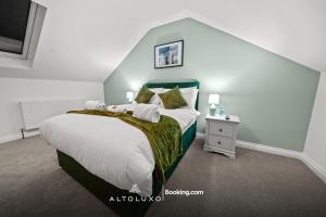 a bedroom with a bed with a green headboard at AltoHaus Luxury 4BR House By AltoLuxo Short Lets & Serviced Accommodation With Parking in Bristol