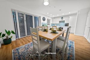 a kitchen and dining room with a wooden table and chairs at AltoHaus Luxury 4BR House By AltoLuxo Short Lets & Serviced Accommodation With Parking in Bristol +53 photos