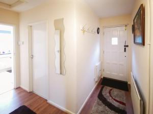 a hallway with white walls and a door at Oak Lodge in Longham