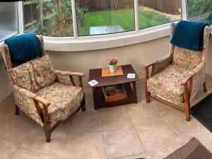two chairs and a coffee table in a living room at Oak Lodge in Longham +3 photos