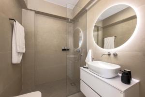 a bathroom with a sink and a mirror at Estia Villas Naxos in Naxos Chora +46 photos