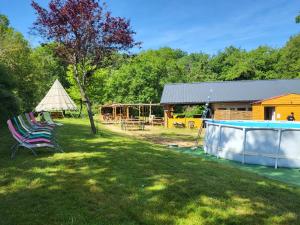 a yard with two lawn chairs and a house at L'alternatif in Huriel