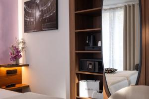 a mirror in a hotel room with a bedroom at Hotel London in Paris