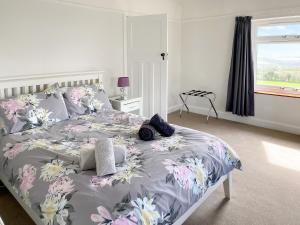 a bedroom with a bed with a floral bedspread at Beacon Cottage in Ivybridge