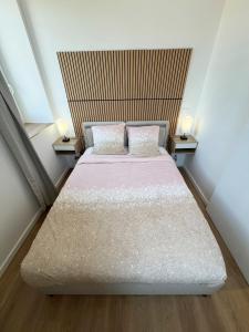 a bedroom with a large bed with two pillows at Voyageur - Vidéoprojecteur - Terrasse - 5min gare in Ploumagoar