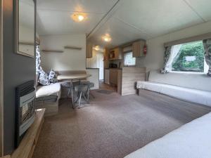 a room with two beds and a table in a caravan at Kingfisher - Uk52120 in Hevingham