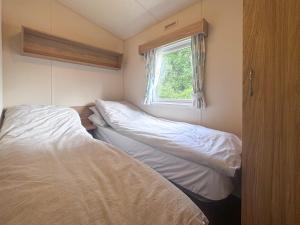 two beds in a small room with a window at Kingfisher - Uk52120 in Hevingham