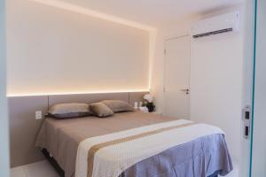 a bedroom with a bed in a white room at Apartamento Bitú in Fortaleza +15 photos