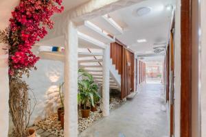 a hallway with flowers and stairs in a building at Pousada Vila DuJu in Porto De Galinhas