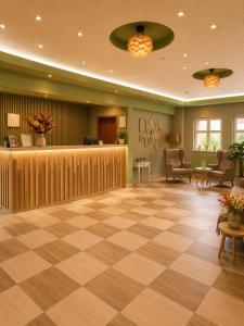 a lobby with a waiting area with a checkered floor at Hotel Olimp in Cluj-Napoca